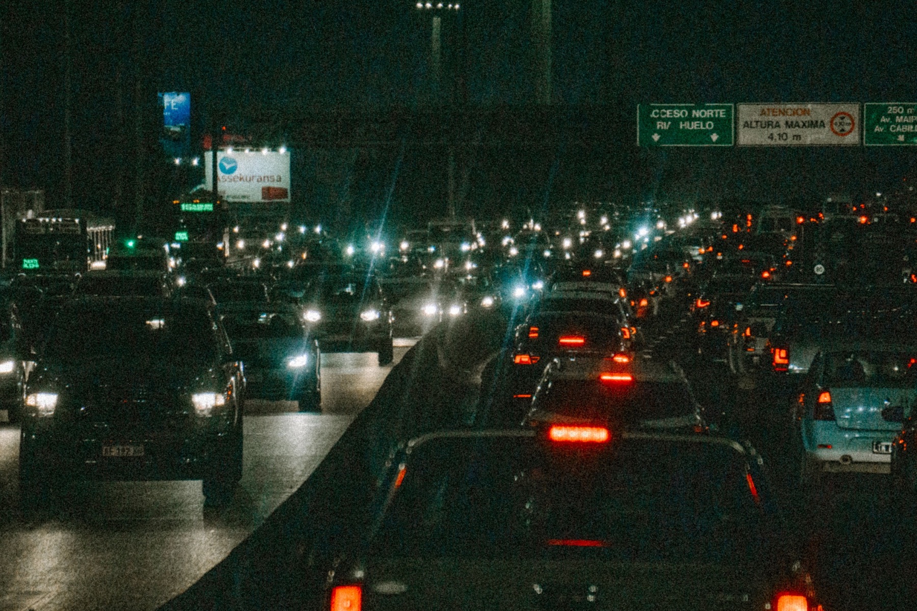 Lines of cars move together through a crowded city at night.